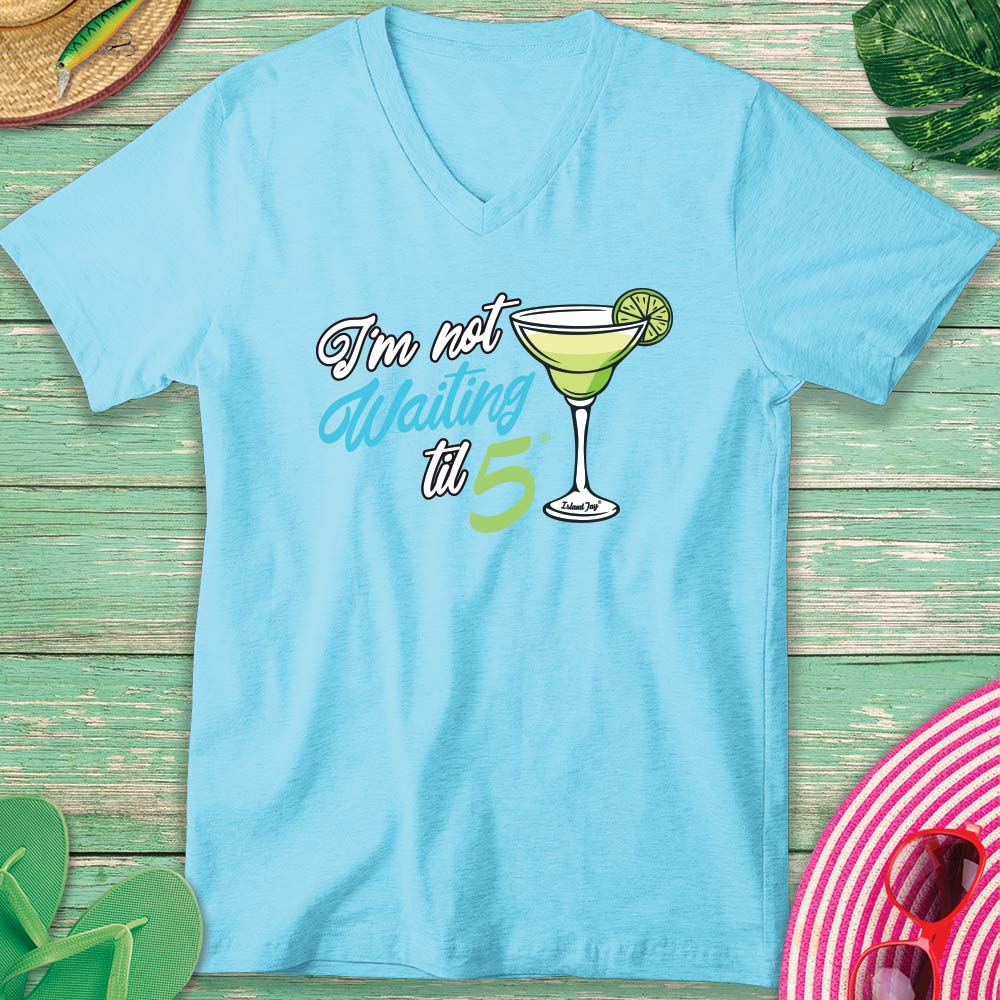 Light blue t-shirt with a cocktail graphic and text on a wooden surface.