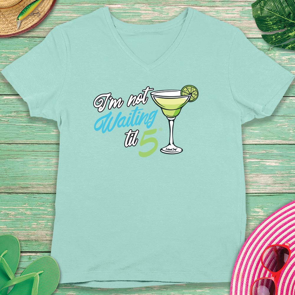 Mint green t-shirt with cocktail graphic and text on a wooden surface