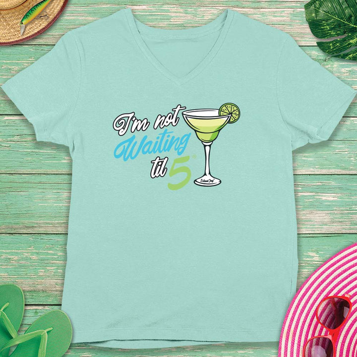 Mint green t-shirt with cocktail graphic and text on a wooden surface