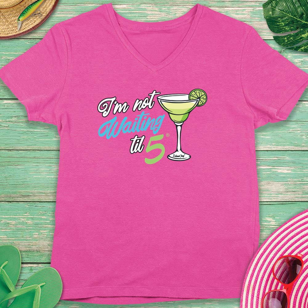 Pink t-shirt with a cocktail graphic and text on a wooden surface