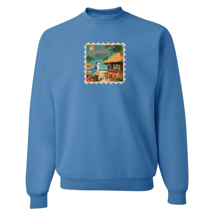 Blue sweatshirt with a tropical stamp design on a white background