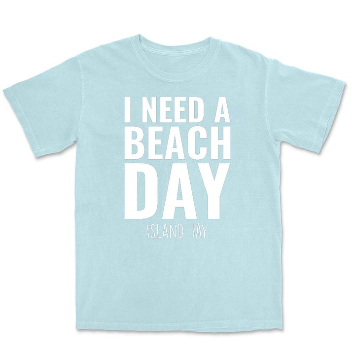 Light blue t-shirt with 'I Need a Beach Day' text on a white background