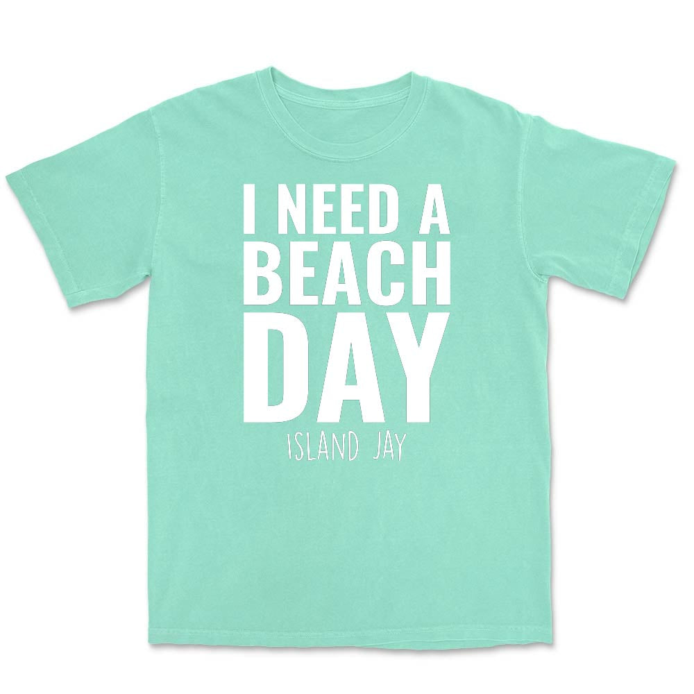 Mint green t-shirt with 'I NEED A BEACH DAY' text on a white background
