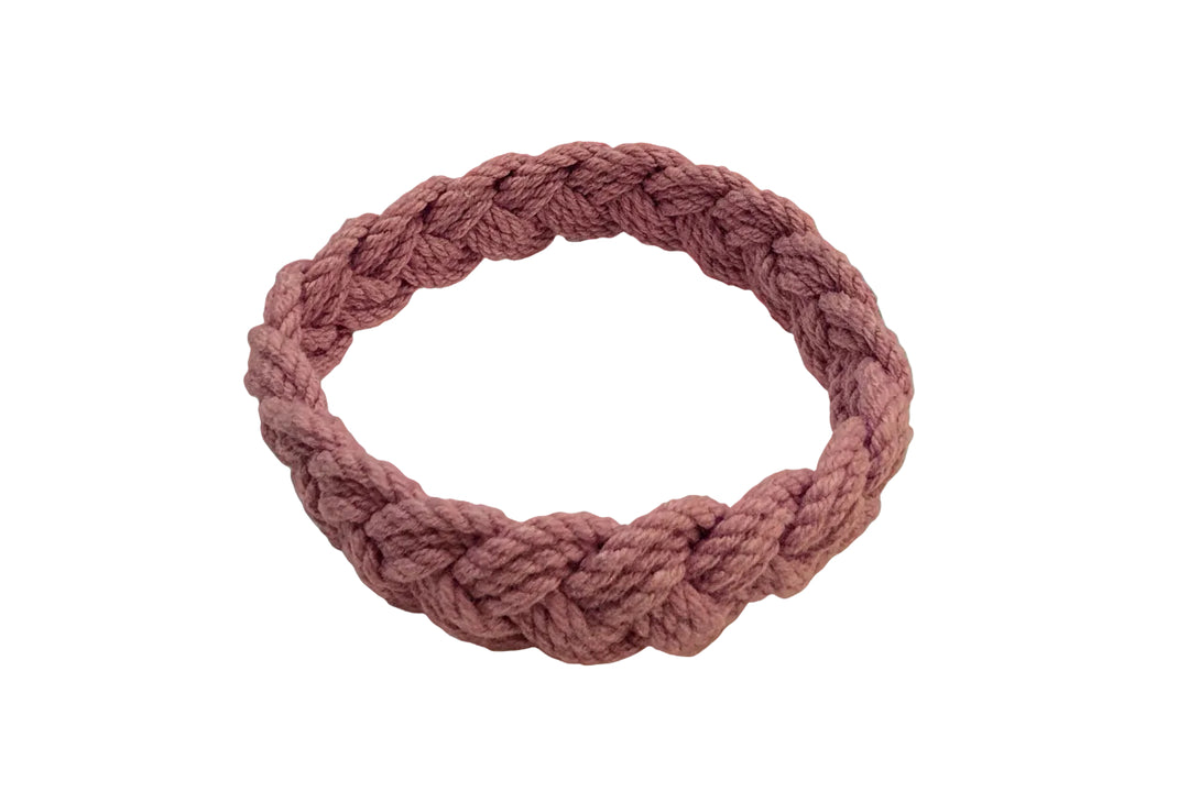 purple braided headband on a beige background