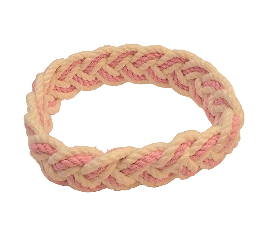 Braided pink and beige hairband on a beige background