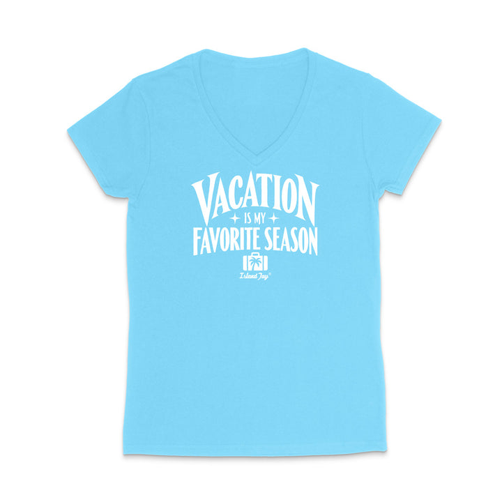 A light blue women's V-neck t-shirt with a white graphic text print reading 'VACATION IS MY FAVORITE SEASON' and a small 'Tulum Trip' logo underneath, displayed on a clean white background.