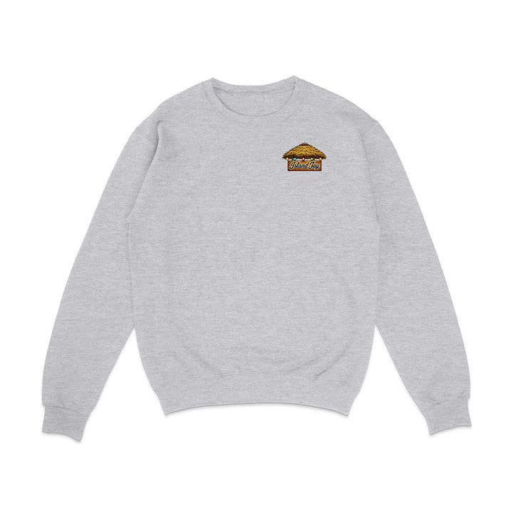 A light heather gray crewneck sweatshirt with a small graphic of a golden-brown taco on the left chest, displayed on a clean white background.