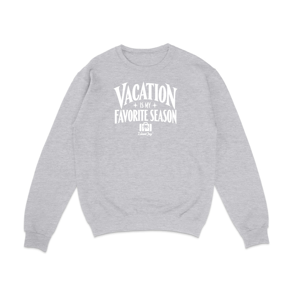 A light heather gray crewneck sweatshirt with a white graphic text print on the chest reading 'VACATION IS MY FAVORITE SEASON' and a small 'it's just me' logo underneath, displayed on a clean white background.