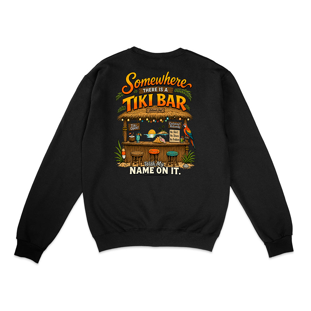 A black crewneck sweatshirt shown from the back, featuring a colorful graphic print of a tropical tiki bar with the text 'Somewhere THERE IS A TIKI BAR and my NAME ON IT.'.