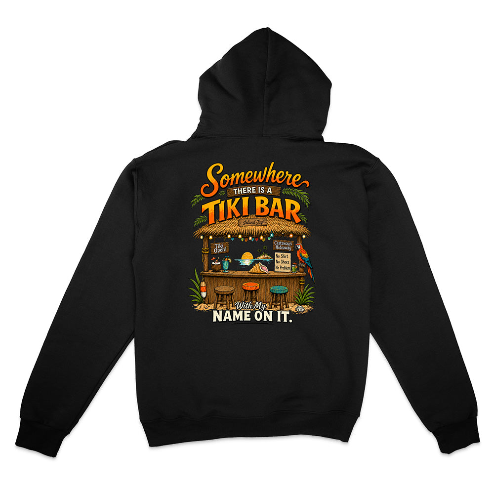 A black pullover hoodie shown from the back, featuring a colorful graphic print of a tiki bar with the text 'Somewhere THERE IS A TIKI BAR' and 'NAME ON IT.'.