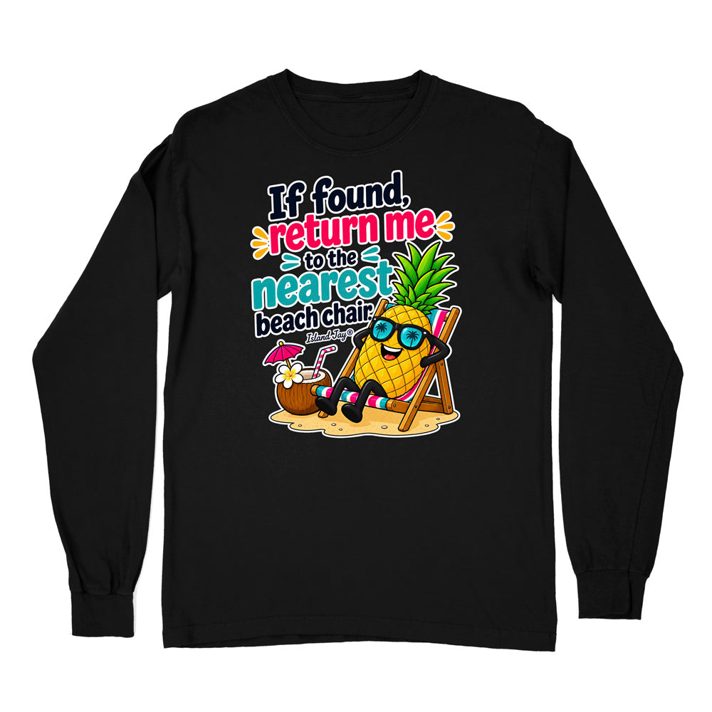 A black long-sleeve t-shirt with a colorful graphic on the chest. The graphic features a cartoon pineapple wearing sunglasses and sitting in a beach chair next to a coconut drink, with the text 'If found, return me to the nearest beach chair' in a playful multicolor font.