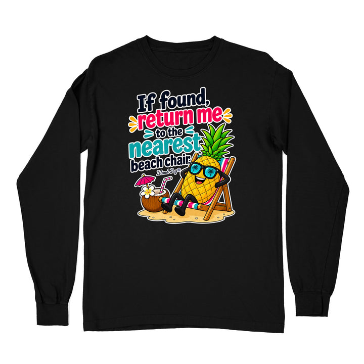 A black long-sleeve t-shirt with a colorful graphic on the chest. The graphic features a cartoon pineapple wearing sunglasses and sitting in a beach chair next to a coconut drink, with the text 'If found, return me to the nearest beach chair' in a playful multicolor font.