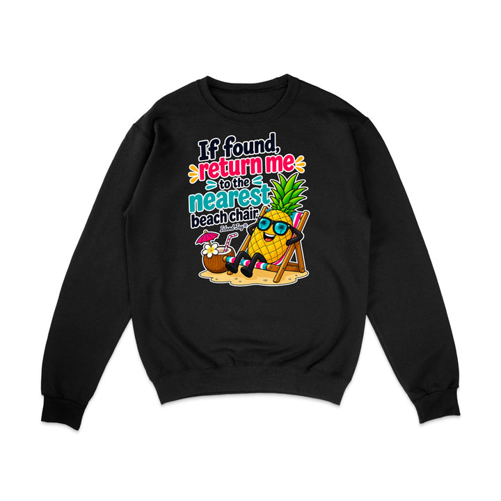 A black crewneck sweatshirt with a colorful graphic print on the front. The graphic features a pineapple wearing sunglasses and a beach chair next to a coconut drink, with the text 'If found, return me to the nearest beach chair'.