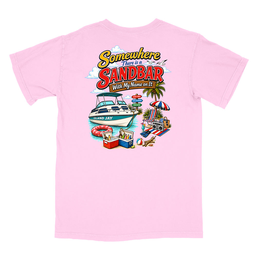A light pink short-sleeve t-shirt with a colorful graphic print on the back. The graphic features the text 'Somewhere There is a SANDBAR Wish My Name was It!' in a retro font, above an illustration of a white motorboat on blue water, a beach umbrella, a striped towel, and a cooler.