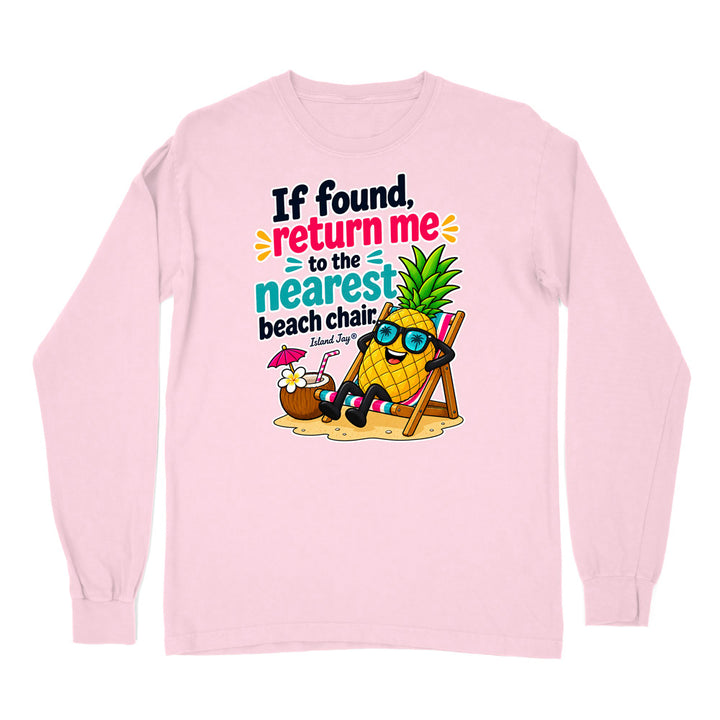 A light pink long-sleeve t-shirt with a colorful graphic print on the front. The graphic features a cartoon pineapple wearing sunglasses and relaxing in a beach chair next to a coconut drink, with the text 'If found, return me to the nearest beach chair.
