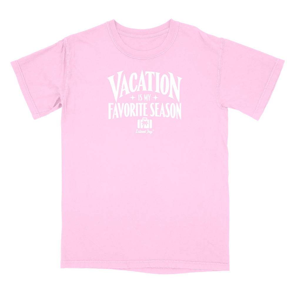 A light pink short-sleeve t-shirt with a white graphic text print reading 'VACATION IS MY FAVORITE SEASON' and a small 'Crazy Dog' logo underneath, displayed on a solid white background.