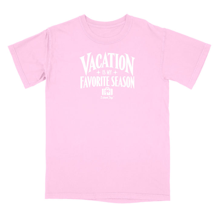 A light pink short-sleeve t-shirt with a white graphic text print reading 'VACATION IS MY FAVORITE SEASON' and a small 'Crazy Dog' logo underneath, displayed on a solid white background.