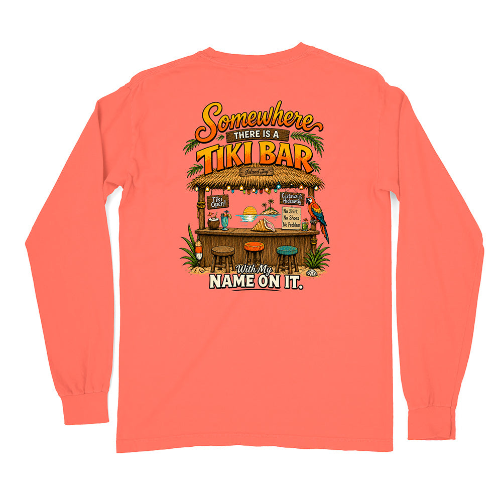 A coral pink long-sleeve t-shirt shown from the back, featuring a colorful graphic print of a tropical 'Tiki Bar' with the text 'Somewhere THERE IS A TIKI BAR' and 'With My NAME ON IT.'.