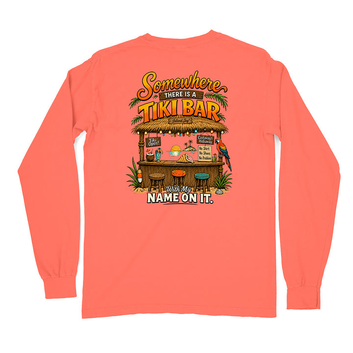 A coral pink long-sleeve t-shirt shown from the back, featuring a colorful graphic print of a tropical 'Tiki Bar' with the text 'Somewhere THERE IS A TIKI BAR' and 'With My NAME ON IT.'.