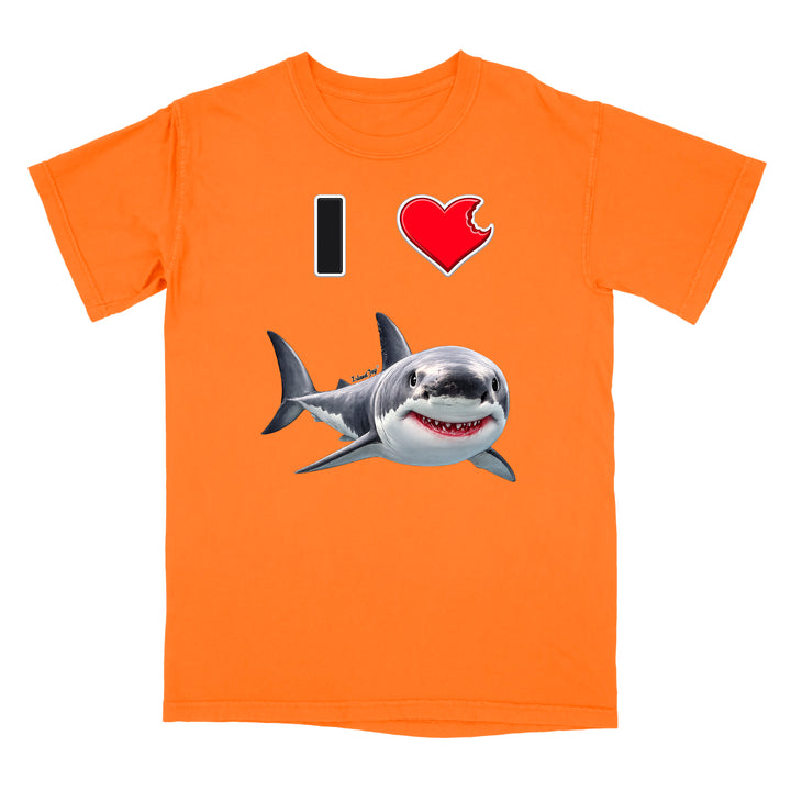 An orange short-sleeve crewneck t-shirt featuring a graphic print of a great white shark and a red heart with a bite taken out of it, alongside a black vertical bar, on a plain white background.