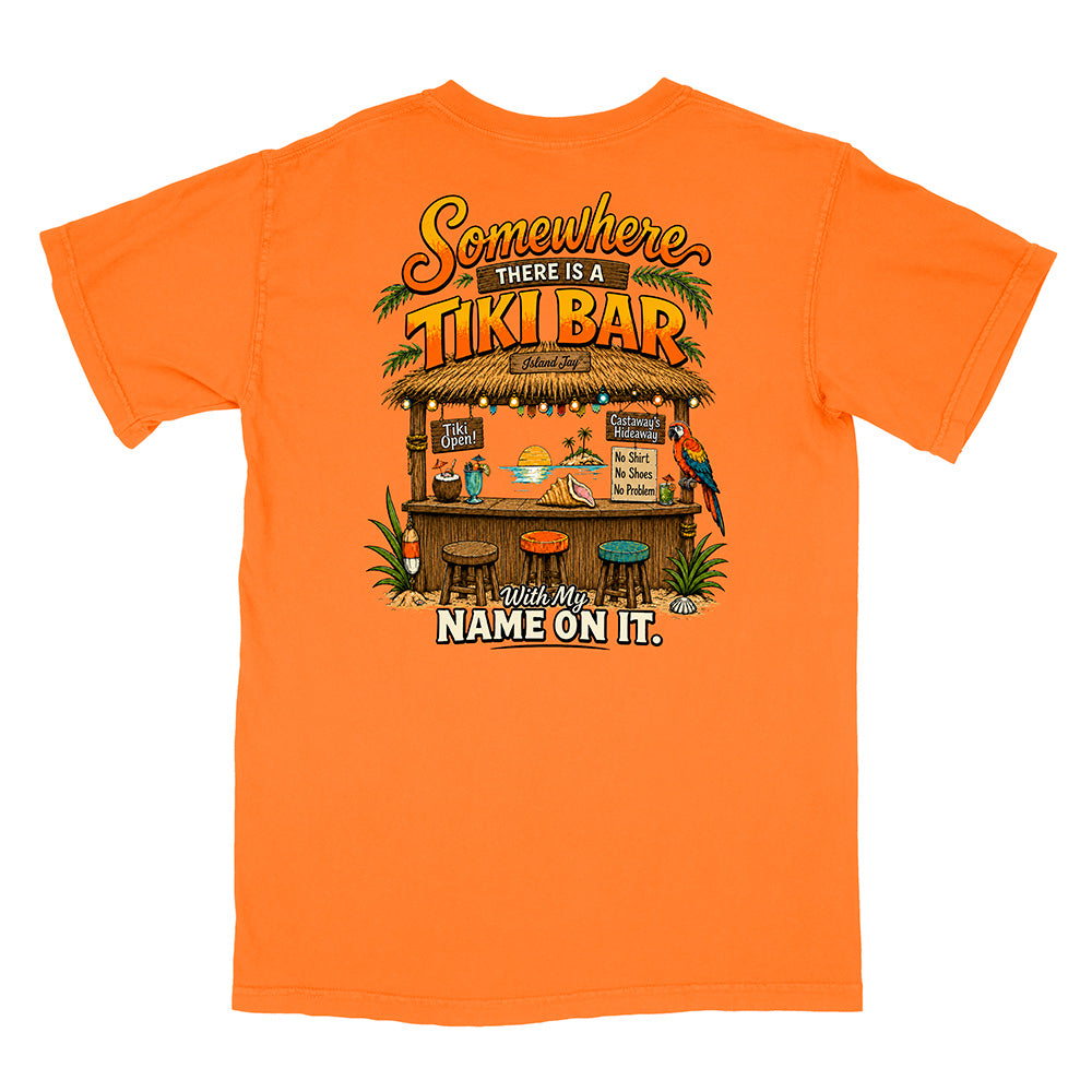 An orange short-sleeve t-shirt with a large graphic print on the back featuring a tropical tiki bar scene and the text 'Somewhere there is a TIKI BAR. Your name will be on it.