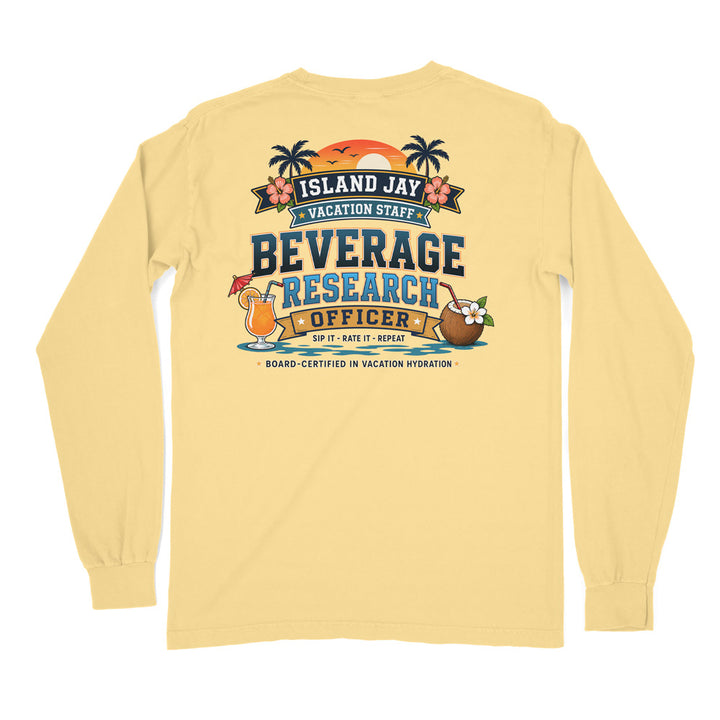 A pale yellow long-sleeve t-shirt shown from the back, featuring a colorful graphic print with palm trees, a sunset, cocktails, and the text 'ISLAND JAY VACATION STAFF BEVERAGE RESEARCH OFFICER'.