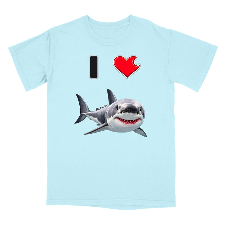 A light blue short-sleeve crewneck t-shirt featuring a graphic print of a great white shark and a red heart with a black 'I' on the chest, representing 'I [love] a shark'.