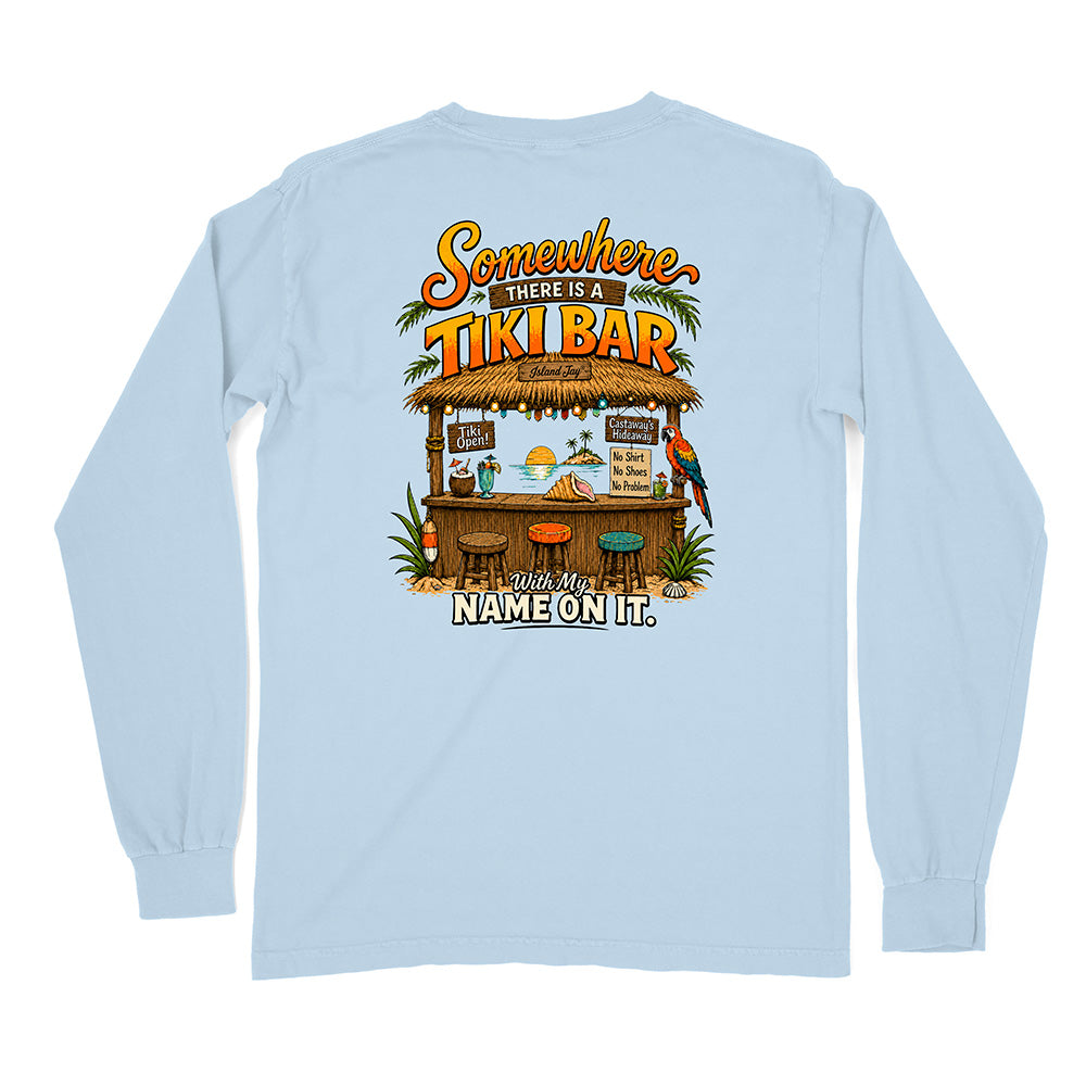 A light blue long-sleeve t-shirt shown from the back, featuring a colorful graphic print of a tropical tiki bar with the text 'Somewhere There Is A TIKI BAR' and 'With My NAME ON IT.'.