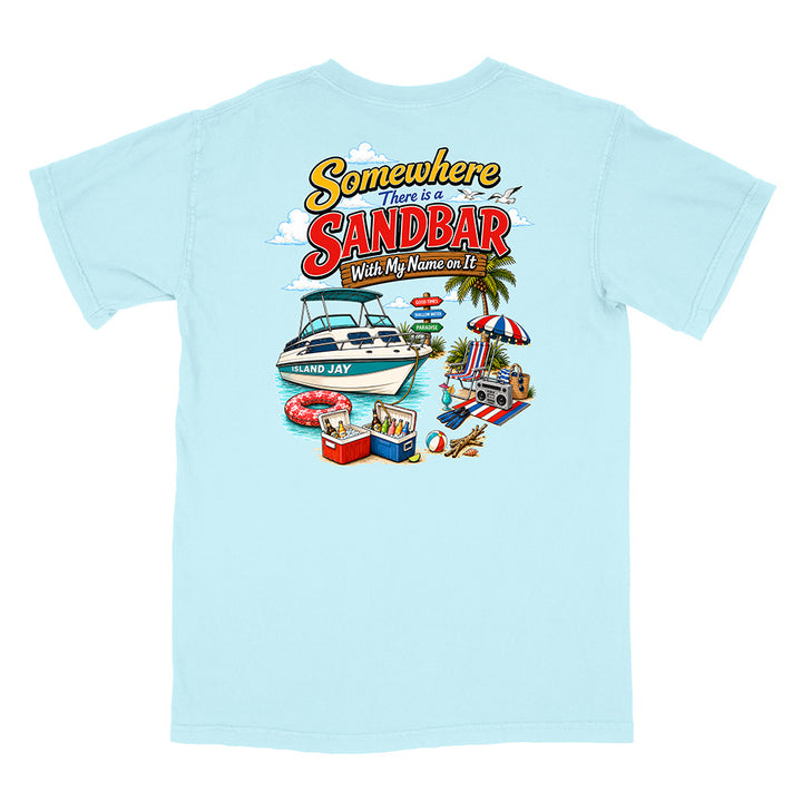 A light blue short-sleeve t-shirt with a colorful graphic print on the back. The graphic features the text 'Somewhere There is a SANDBAR Wish My Name was It' above an illustration of a white motorboat, palm trees, a beach umbrella, a cooler, and a beach chair.