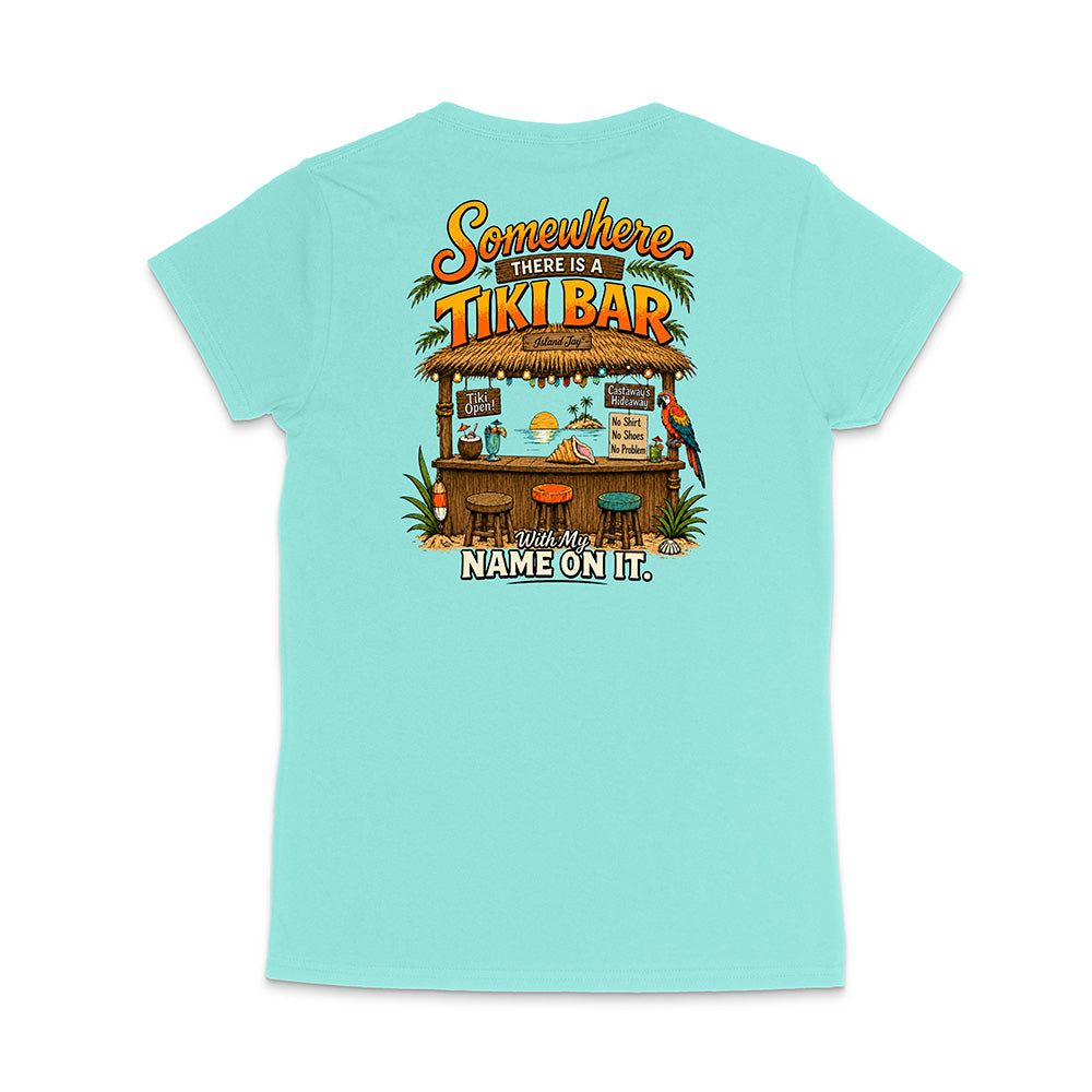 A light aqua blue short-sleeve t-shirt shown from the back, featuring a colorful graphic of a tropical 'Tiki Bar' with the text 'Somewhere there is a TIKI BAR' and 'With my NAME ON IT'.