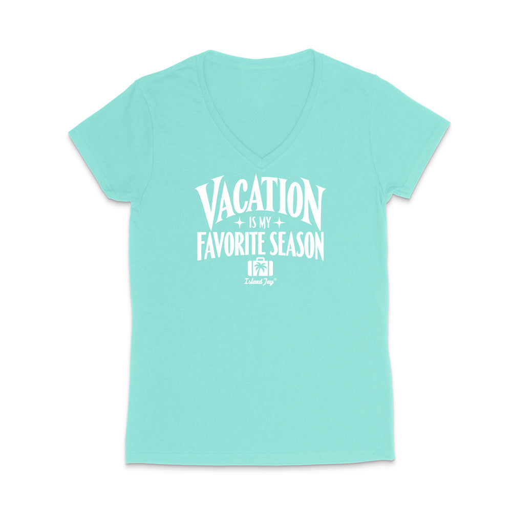 A light aqua V-neck t-shirt with a white graphic print that reads 'VACATION IS MY FAVORITE SEASON' and a small 'Tulum Trip' logo underneath, displayed on a clean white background.