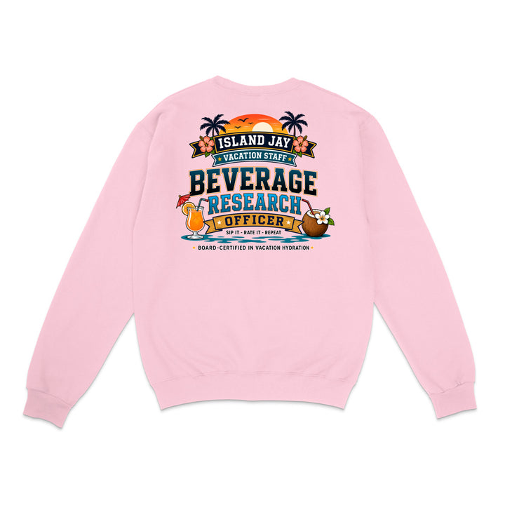 A light pink crewneck sweatshirt shown from the back, featuring a colorful graphic print with a sunset, palm trees, and a cocktail, with text reading 'ISLAND JAY VACATION STAFF BEVERAGE RESEARCH OFFICER'.