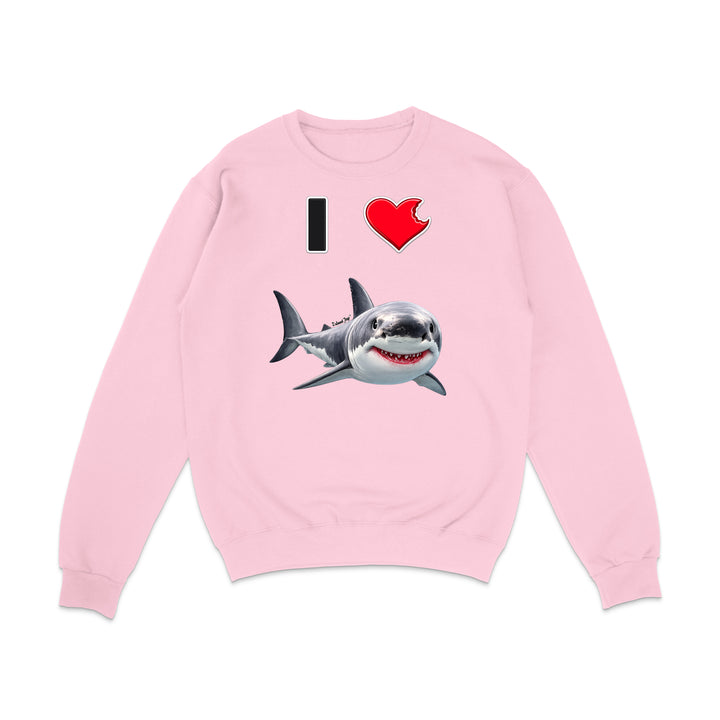 A light pink crewneck sweatshirt featuring a graphic print of a great white shark and the text 'I' followed by a red heart, displayed on a clean white background.