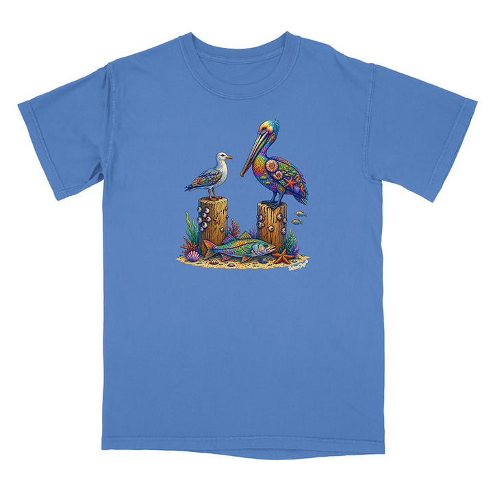 Blue t-shirt with a colorful graphic of two birds on logs and marine life.