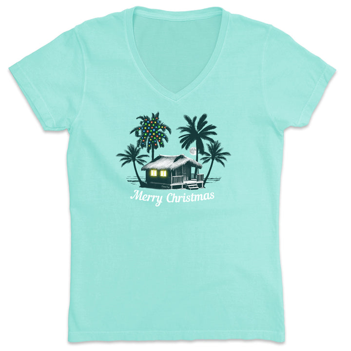Women's Deck the Palms: All Is Calm V-Neck T-Shirts. Featuring a nighttime design of a beach house by the ocean with palm trees. One of the palm trees has christmas lights on it. 