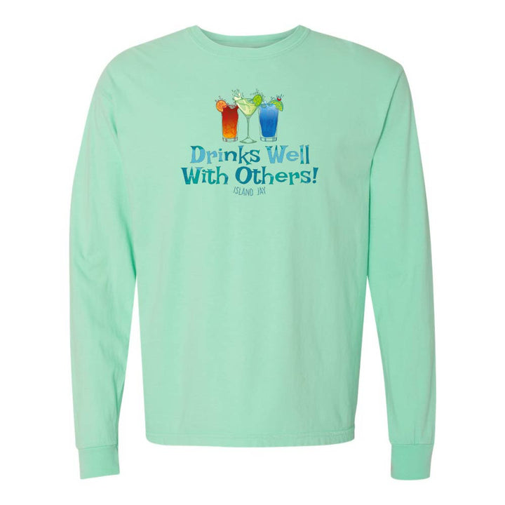 Light green long sleeve T-shirt with mixed drinks graphic and text reading "Drinks Well With Others!"