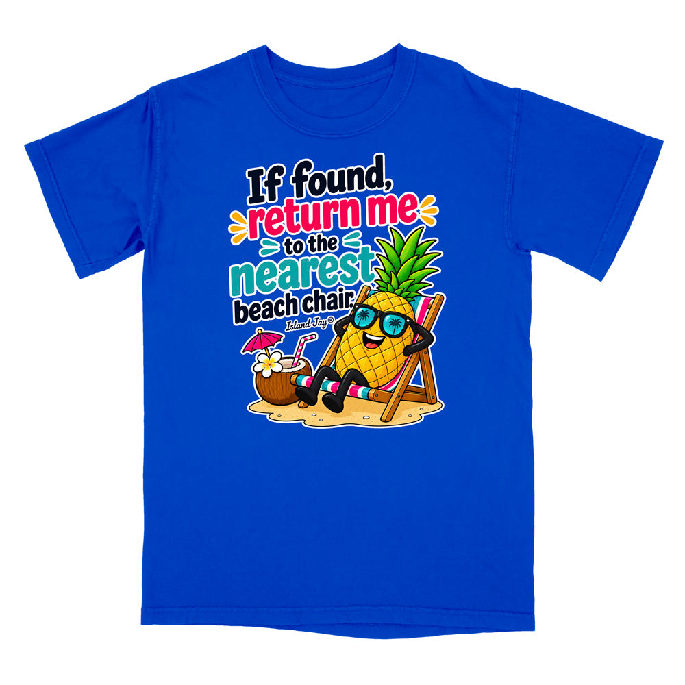 A royal blue short-sleeve t-shirt with a colorful graphic of a pineapple character wearing sunglasses and sitting in a beach chair next to a coconut drink, with the text 'If found, return me to the nearest beach chair' printed on the front.