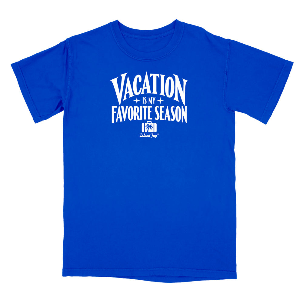 A royal blue short-sleeve crewneck t-shirt with a white graphic print on the front that reads 'VACATION IS MY FAVORITE SEASON' with a small 'Delmarc Shop' logo underneath, displayed on a solid white background.