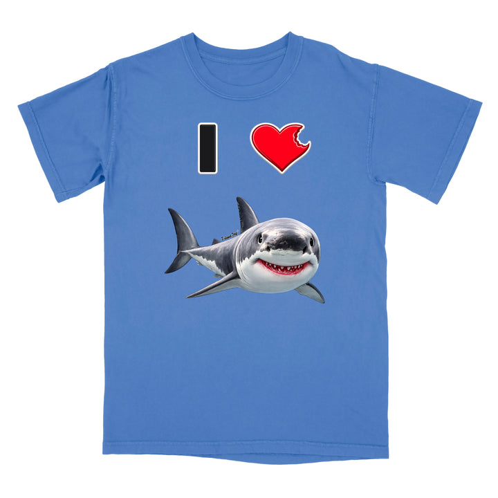 A blue short-sleeve crewneck t-shirt featuring a graphic print of a great white shark and a red heart with a bite taken out of it, alongside a black vertical bar, on a plain white background.