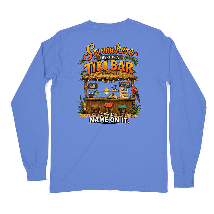 A blue long-sleeve t-shirt shown from the back, featuring a colorful graphic of a tropical tiki bar with the text 'Somewhere THERE IS A TIKI BAR' and 'With My NAME ON IT.'.