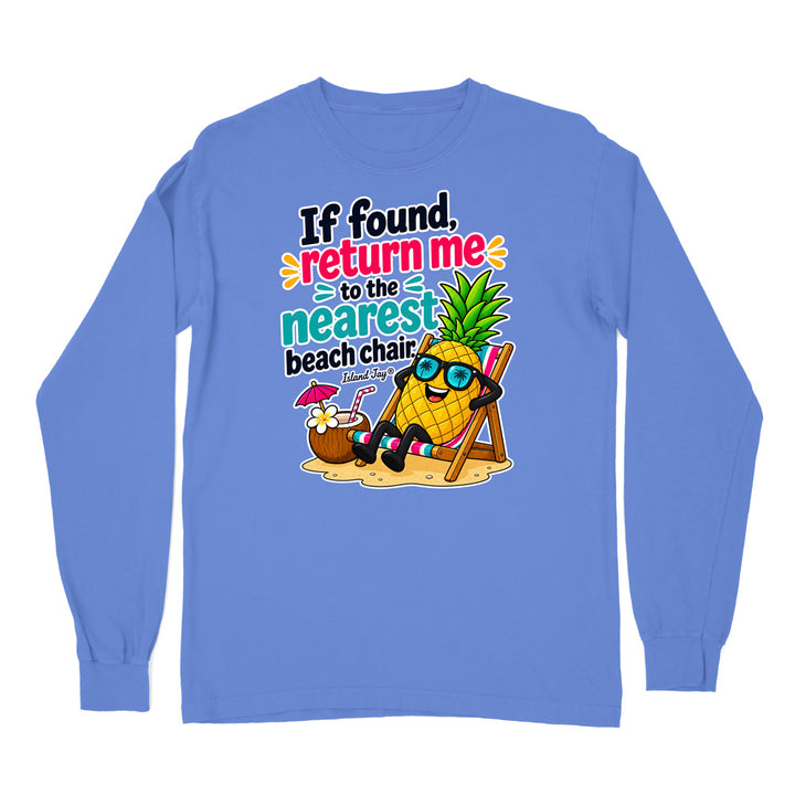 A light blue long-sleeve t-shirt with a colorful graphic print on the front. The graphic features a cartoon pineapple wearing sunglasses and relaxing in a beach chair next to a coconut drink, with the text 'If found, return me to the nearest beach chair.