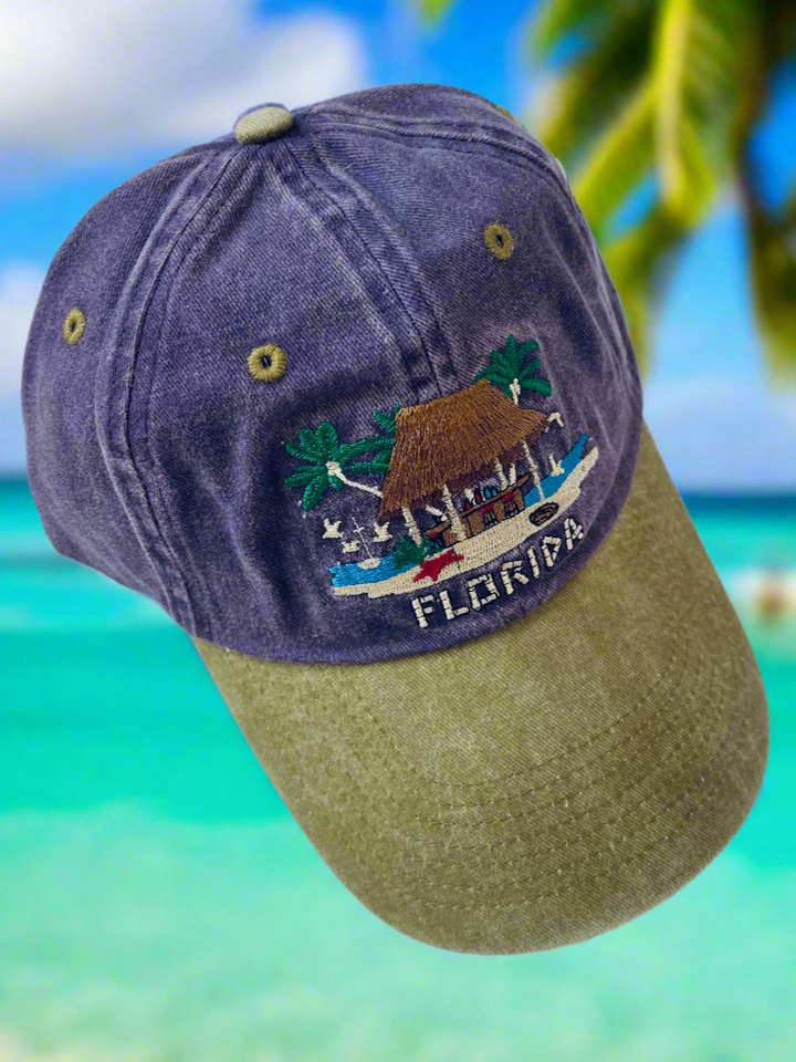 Purple baseball cap with the stitched image of a tiki bar on it with "Florida" stitched under the bar.
