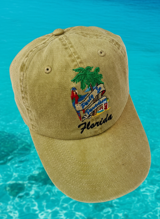 Beige cap with a palm tree and 'Florida' text floating in clear blue water with a tropical island in the background.