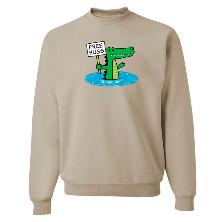 Beige sweatshirt with a cartoon alligator holding a 'Free Hugs' sign on a white background