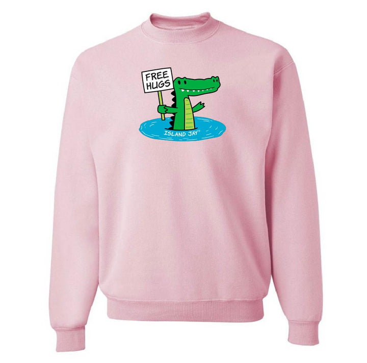 Pink sweatshirt with a cartoon alligator holding a 'Free Hugs' sign on a white background