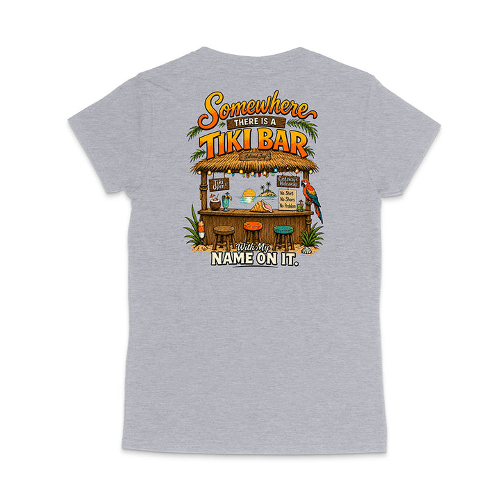 A heather gray short-sleeve t-shirt shown from the back, featuring a colorful graphic print of a tropical 'Tiki Bar' with the text 'Somewhere there is a TIKI BAR' and 'With my NAME ON IT.'.