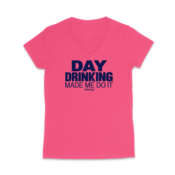 A bright pink women's V-neck t-shirt with a dark navy blue graphic text print reading 'DAY DRINKING MADE ME DO IT' and a small 'I Love Joy' logo underneath, displayed on a clean white background.