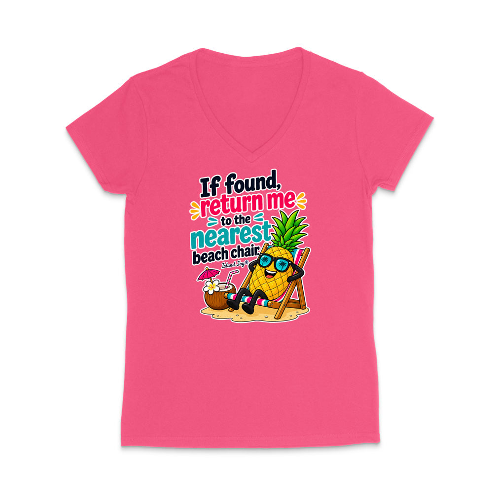 A bright pink women's V-neck t-shirt with a colorful graphic of a pineapple character wearing sunglasses and sitting in a beach chair next to a coconut drink, with the text 'If found, return me to the nearest beach chair'.