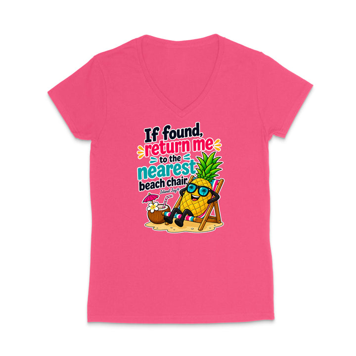 A bright pink women's V-neck t-shirt with a colorful graphic of a pineapple character wearing sunglasses and sitting in a beach chair next to a coconut drink, with the text 'If found, return me to the nearest beach chair'.