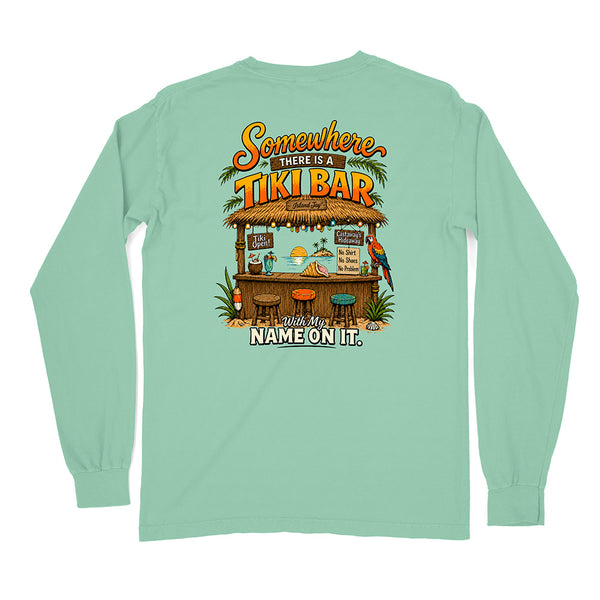A mint green long-sleeve t-shirt shown from the back, featuring a colorful graphic of a tropical tiki bar with the text 'Somewhere There Is A TIKI BAR' and 'With My NAME ON IT.'.
